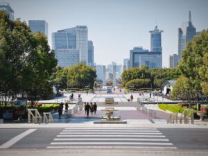 people sitting on bench near trees and buildings during daytime