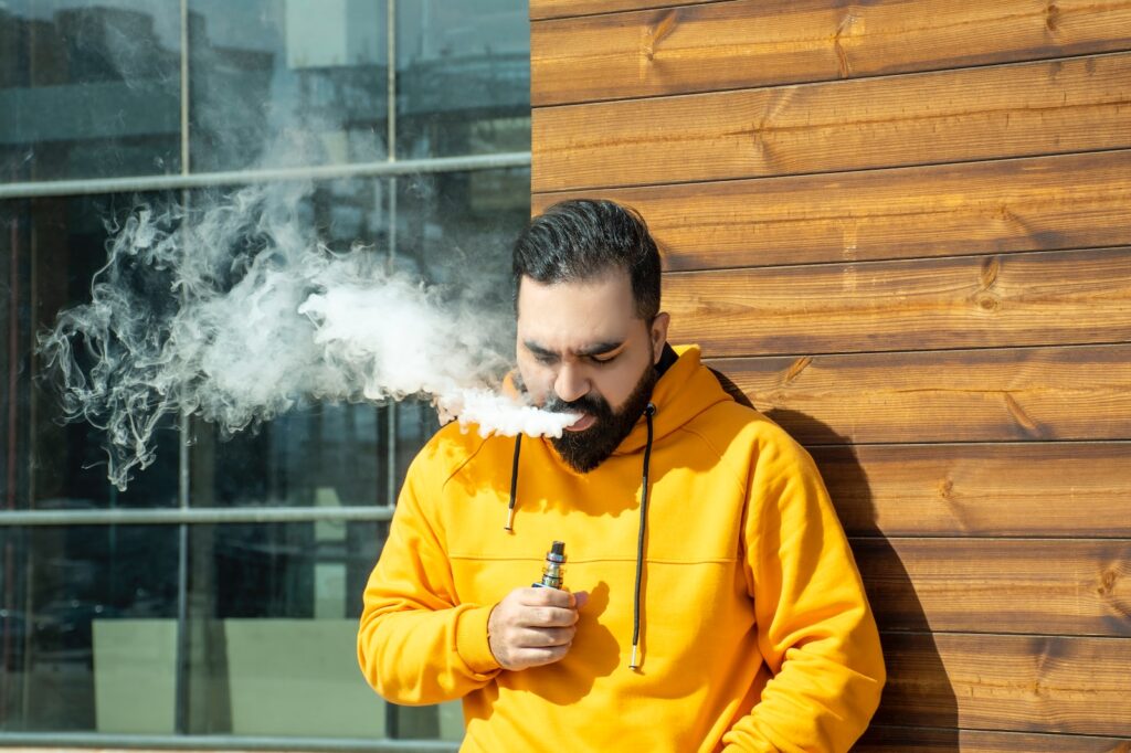 man in yellow jacket smoking