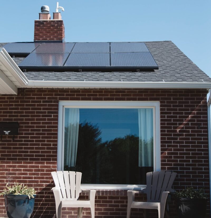 brown brick house with solar panels on roof