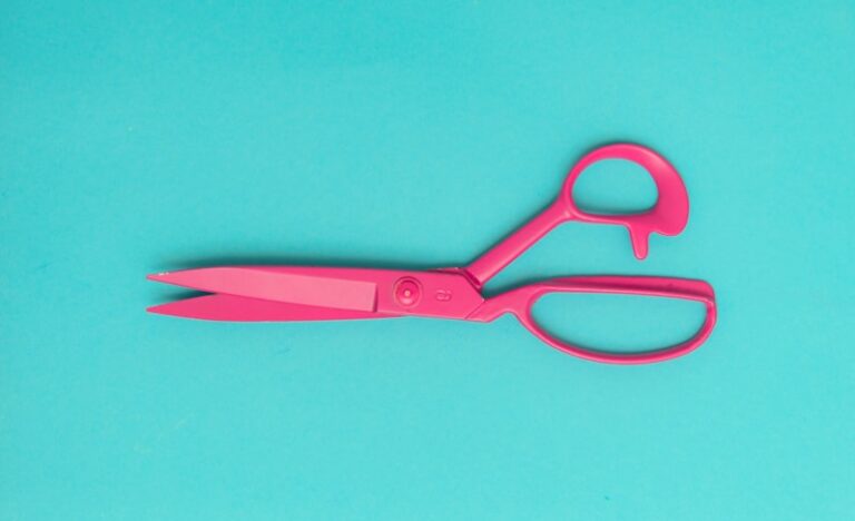 red handled scissors on blue surface