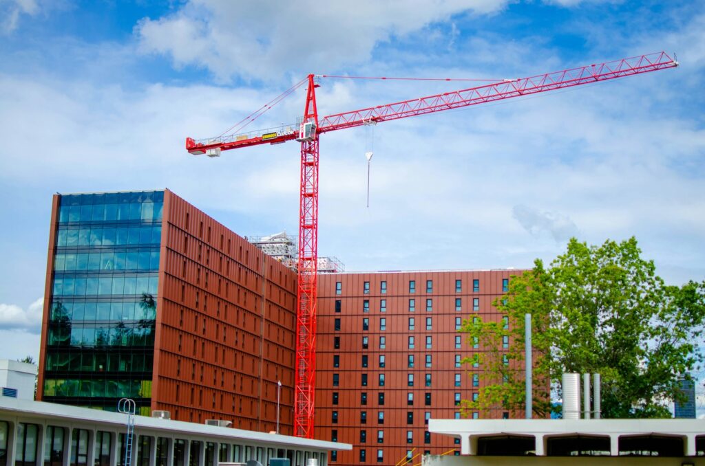 A crane is standing in front of a building under construction