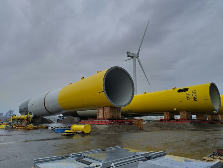 a yellow wind turbine sitting on top of a tarmac