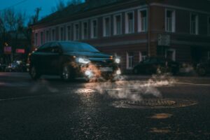 a car driving down a street next to a fire hydrant
