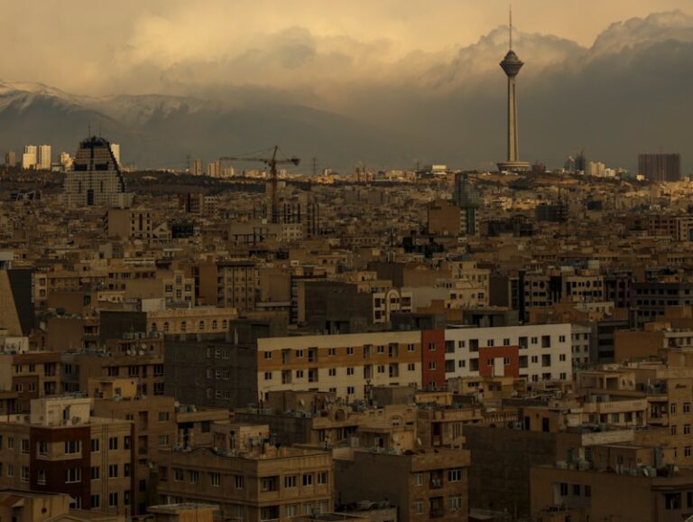 city with high rise buildings under white clouds during daytime