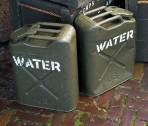 a couple of green containers sitting on top of a brick floor