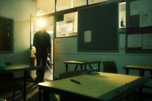 a person standing in a room with a chalkboard and tables
